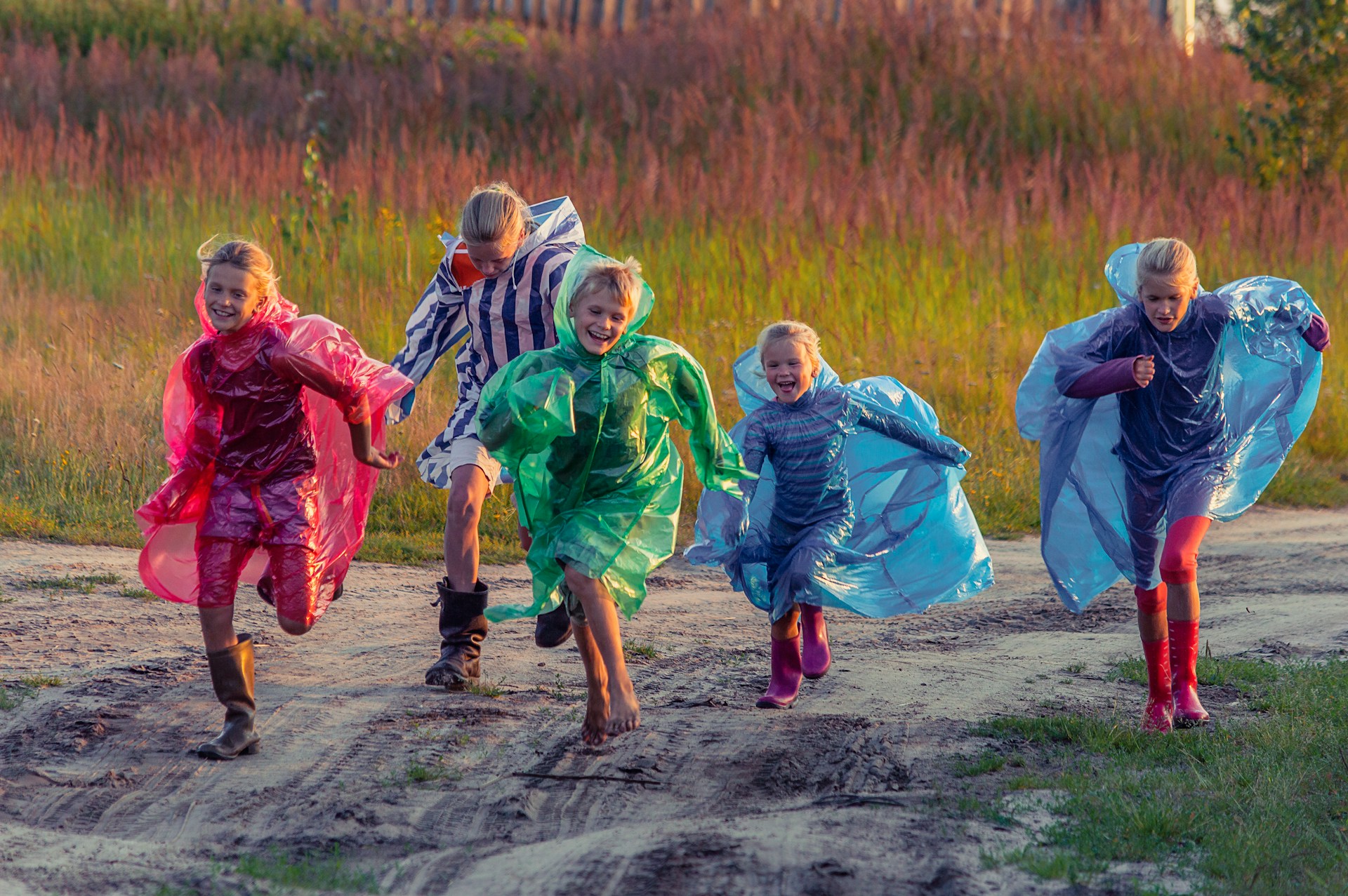 people in green and blue jacket walking on dirt road during daytime